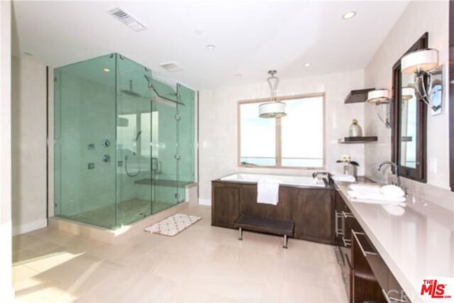 bathroom with tile patterned flooring, vanity, and separate shower and tub