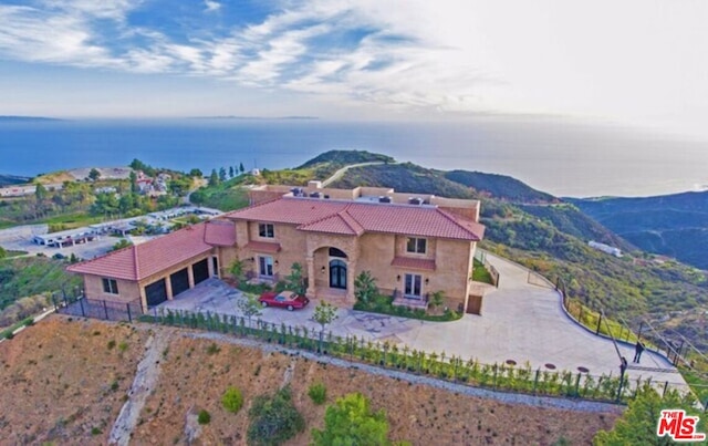 view of front of property featuring a garage and a water view