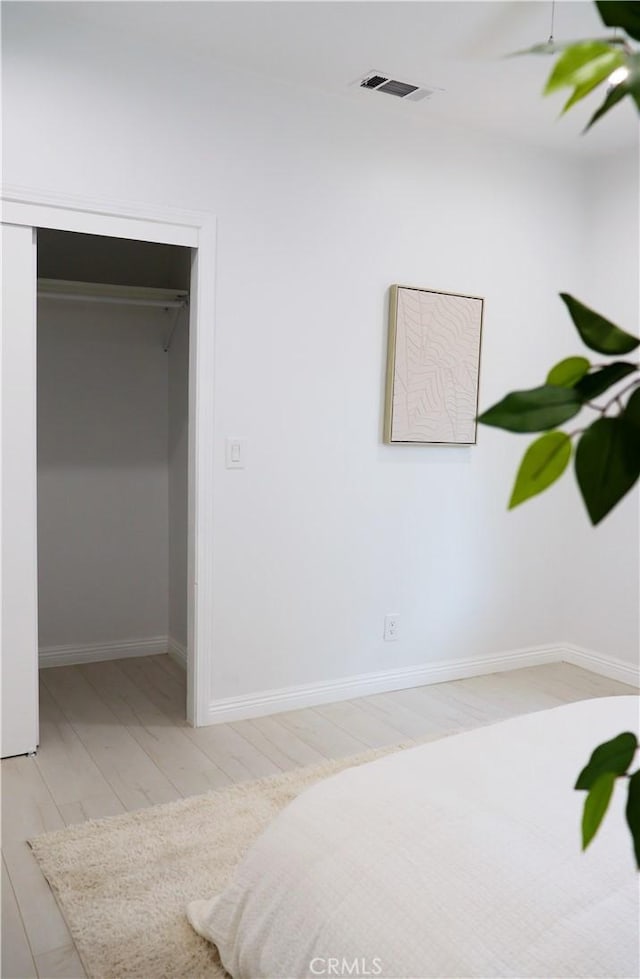 unfurnished bedroom with a closet and light wood-type flooring