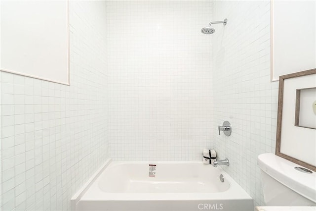 bathroom featuring tiled shower / bath combo and toilet