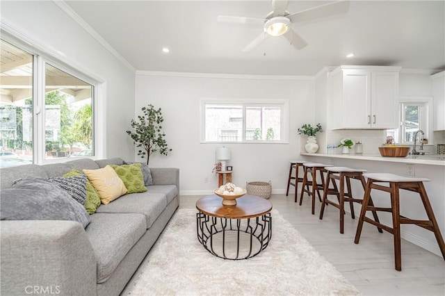 living room with ornamental molding, ceiling fan, and a healthy amount of sunlight