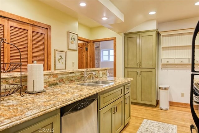 kitchen featuring green cabinets, sink, stainless steel dishwasher, light hardwood / wood-style floors, and light stone counters