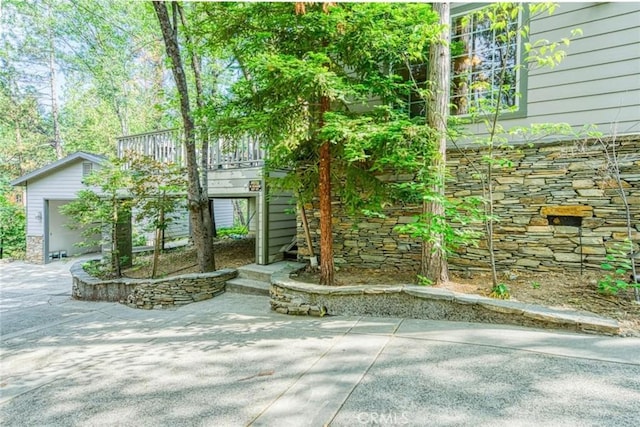 exterior space featuring a garage, an outbuilding, and a patio