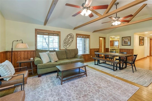 living room with lofted ceiling with beams, ceiling fan, and light wood-type flooring