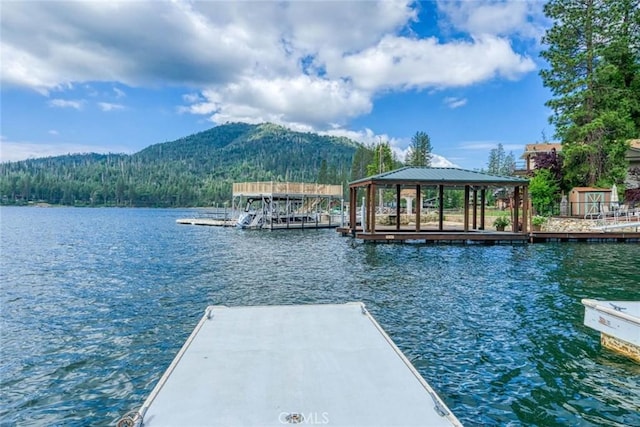 view of dock with a gazebo and a water and mountain view