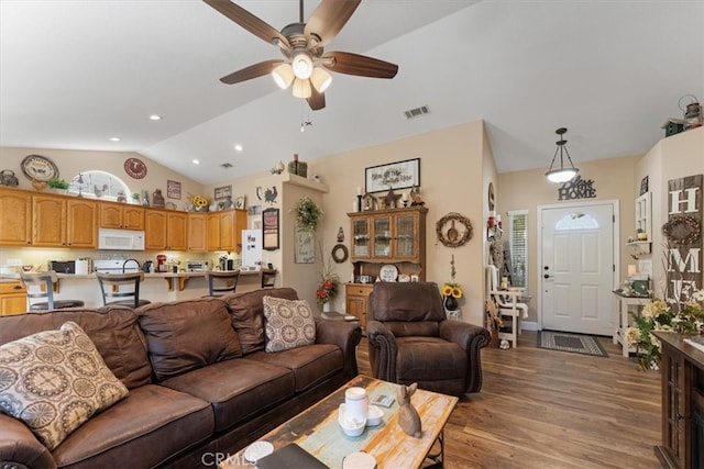 living room with ceiling fan, hardwood / wood-style flooring, and lofted ceiling