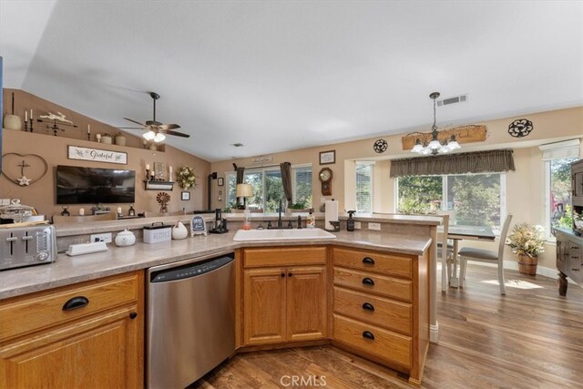 kitchen featuring dishwasher, sink, ceiling fan with notable chandelier, lofted ceiling, and light hardwood / wood-style flooring