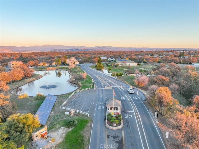 aerial view at dusk featuring a water and mountain view