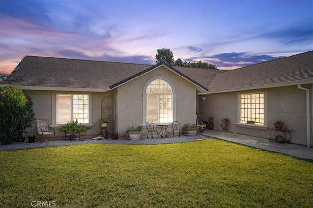 view of front of home with a lawn and a patio