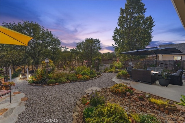 yard at dusk featuring a patio and an outdoor living space