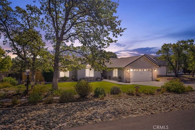 ranch-style home featuring a lawn and a garage