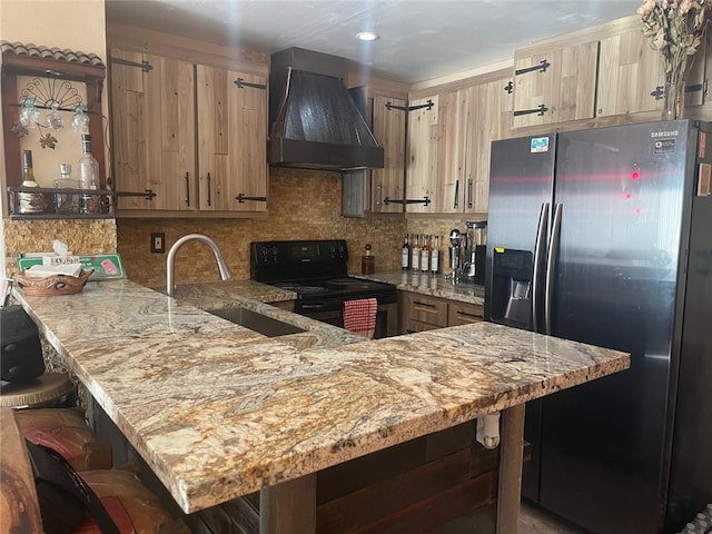 kitchen featuring stainless steel fridge, a breakfast bar, black range with electric cooktop, custom exhaust hood, and sink