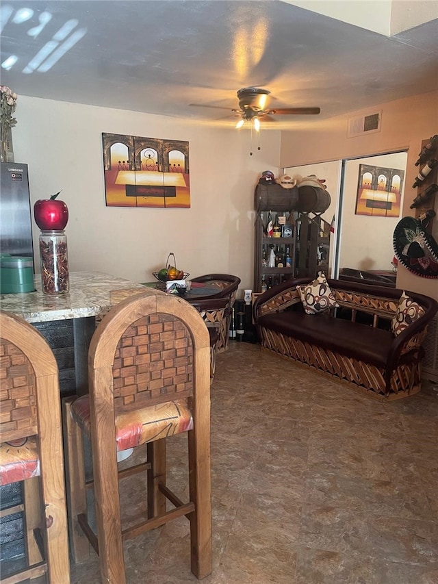 interior space featuring indoor bar and ceiling fan