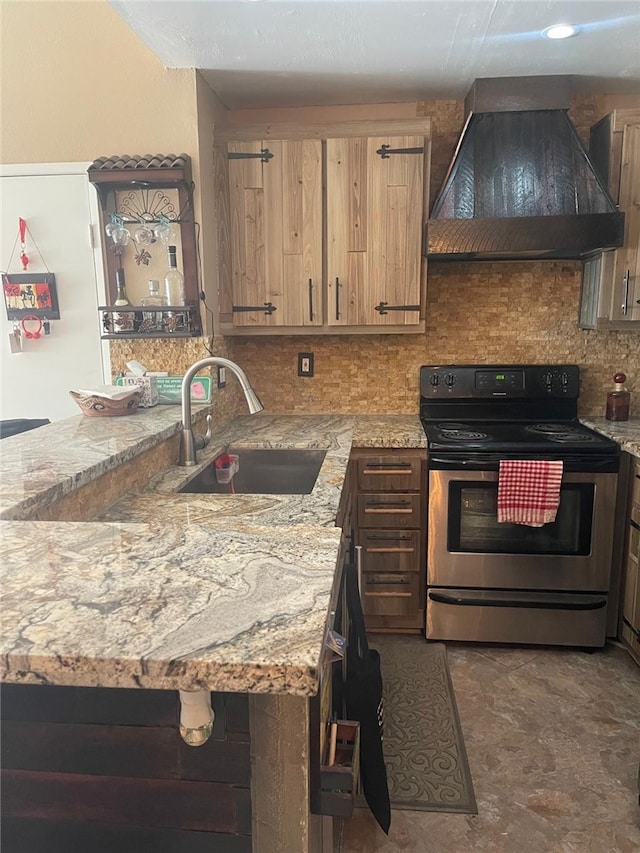 kitchen featuring light stone counters, tasteful backsplash, sink, stainless steel electric stove, and premium range hood