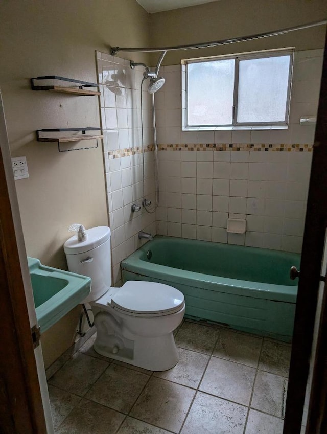 bathroom with toilet and tiled shower / bath combo