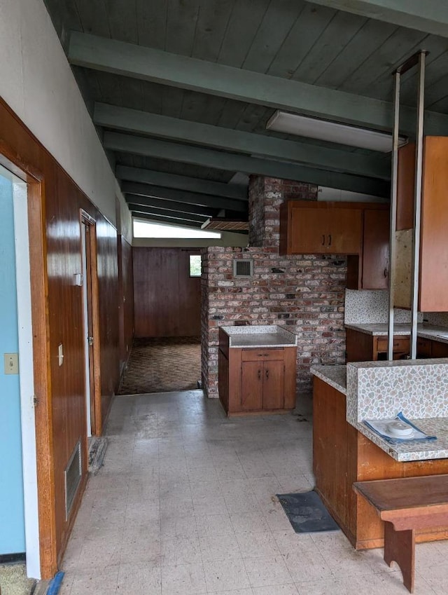 kitchen with wooden walls and vaulted ceiling with beams