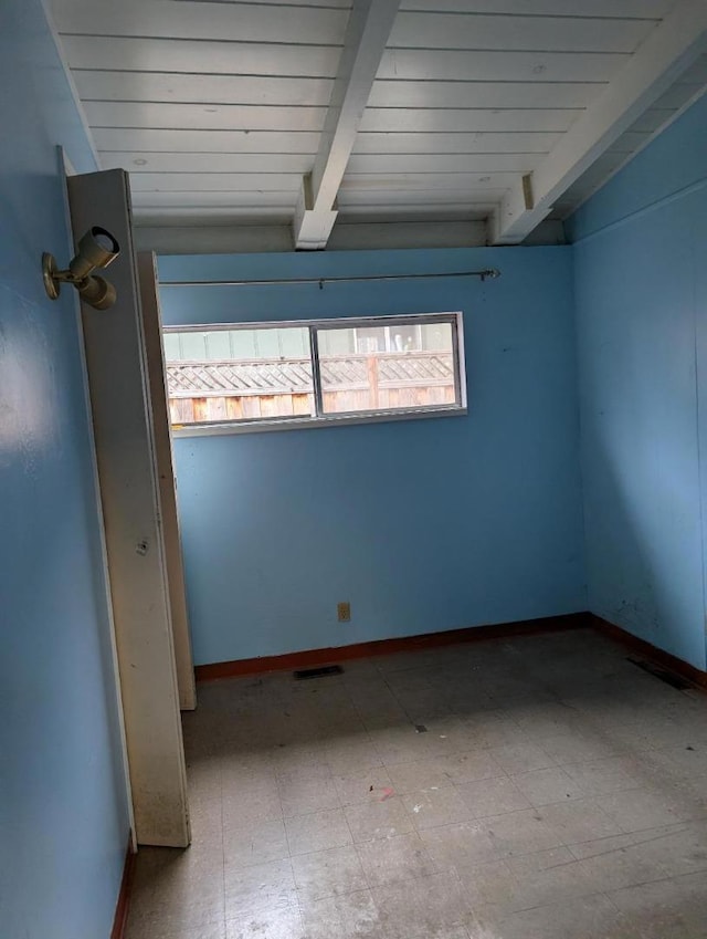 spare room featuring beam ceiling and wooden ceiling