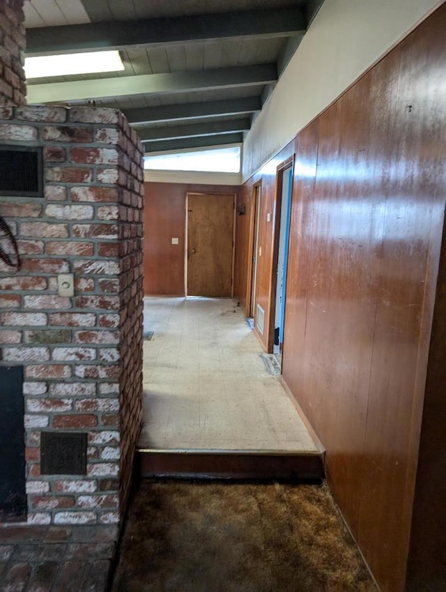 corridor featuring vaulted ceiling with beams and wood walls