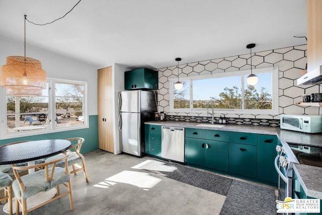 kitchen featuring decorative light fixtures, sink, appliances with stainless steel finishes, and a healthy amount of sunlight