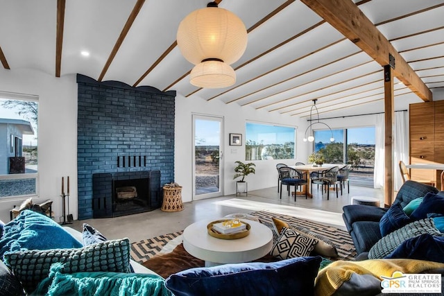 living room featuring concrete floors, a fireplace, and vaulted ceiling with beams