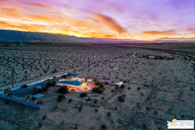 aerial view at dusk featuring a mountain view