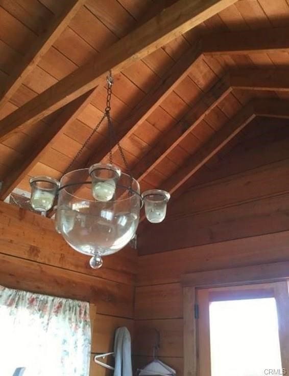 room details featuring wooden walls, wood ceiling, and beam ceiling