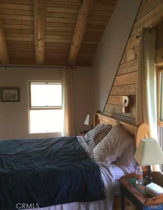 bedroom with wooden ceiling and vaulted ceiling with beams