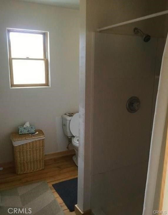 bathroom with walk in shower, hardwood / wood-style floors, and toilet