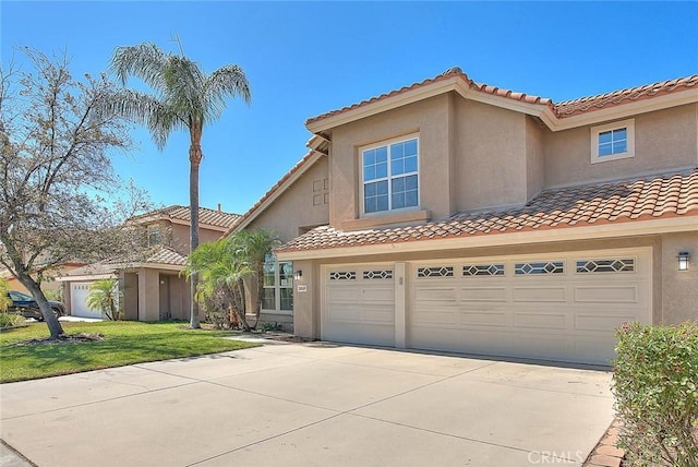 mediterranean / spanish-style home with a garage and a front lawn