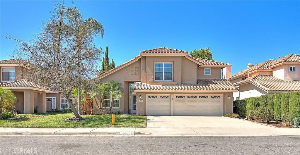 mediterranean / spanish house featuring a garage and a front lawn