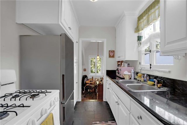 kitchen featuring white cabinets, sink, white gas stove, and a wealth of natural light