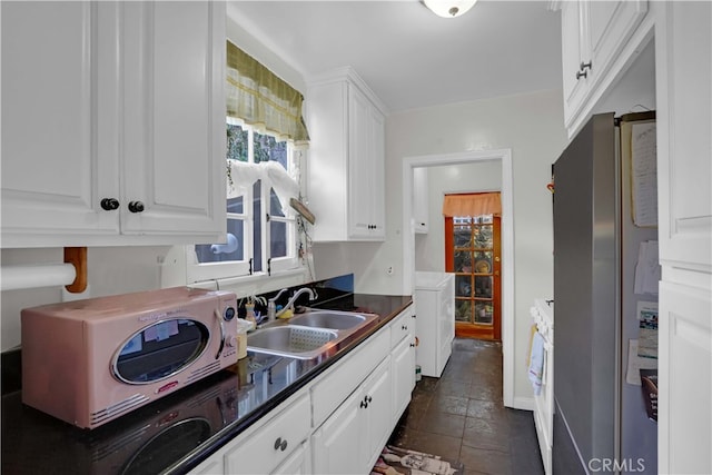 kitchen with washer / clothes dryer, sink, white cabinets, stainless steel refrigerator, and white range oven