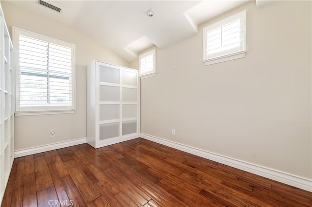 spare room with wood-type flooring and lofted ceiling