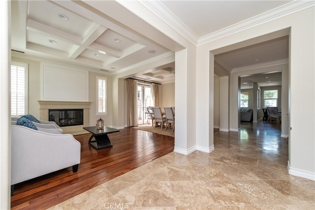 living room with coffered ceiling, plenty of natural light, ornamental molding, and hardwood / wood-style flooring