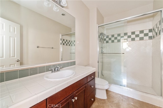 bathroom featuring walk in shower, vanity, tile patterned flooring, and toilet