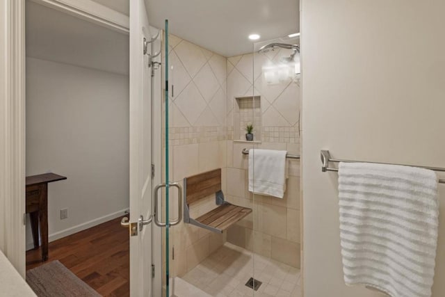 bathroom with wood-type flooring and an enclosed shower