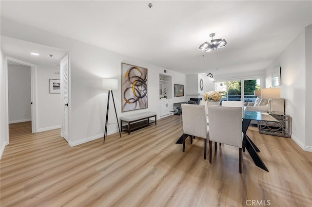 dining room featuring light wood-type flooring and an inviting chandelier