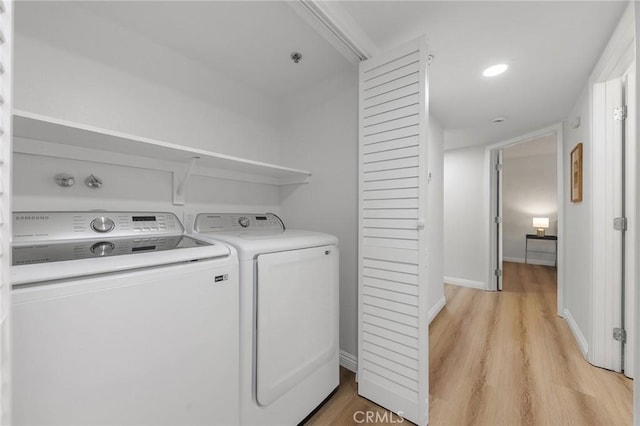 clothes washing area featuring washer and dryer and light hardwood / wood-style floors