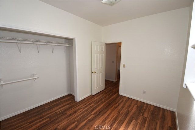 unfurnished bedroom featuring a closet and dark hardwood / wood-style flooring