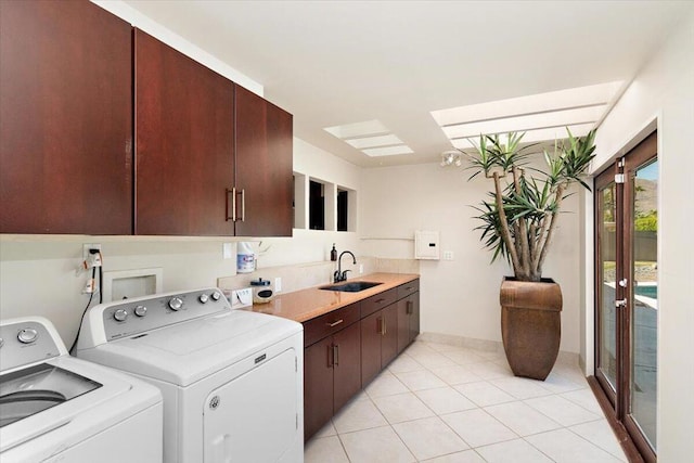 laundry area featuring separate washer and dryer, sink, light tile patterned flooring, and cabinets