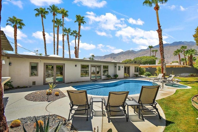 view of pool with an in ground hot tub, a mountain view, a patio, and french doors