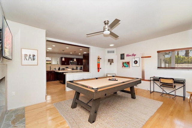 playroom with ceiling fan, light hardwood / wood-style floors, a fireplace, and pool table