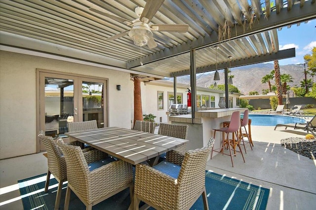 view of patio / terrace with a mountain view, ceiling fan, and an outdoor bar