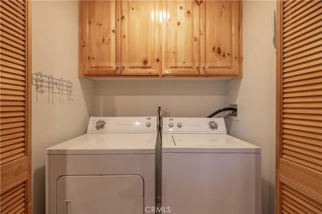 washroom featuring cabinets and washing machine and clothes dryer