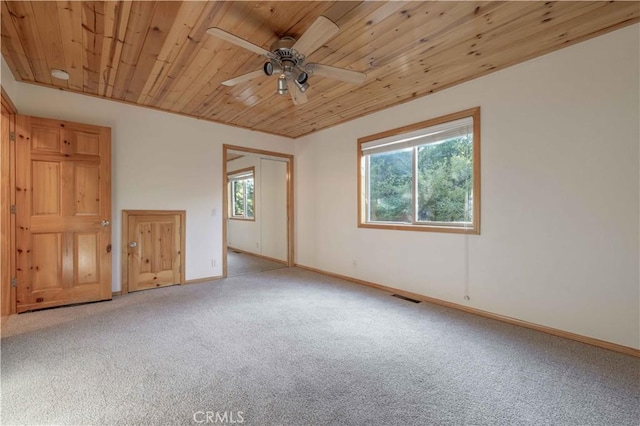 empty room featuring light carpet, ceiling fan, and wood ceiling