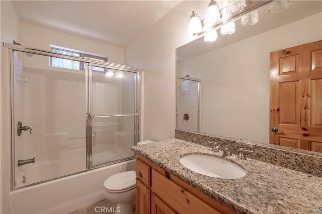 full bathroom featuring vanity, toilet, and bath / shower combo with glass door