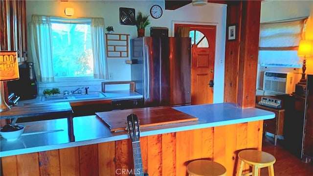 kitchen featuring cooling unit, sink, and stainless steel refrigerator