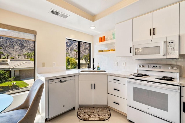 kitchen with white cabinets, plenty of natural light, sink, and white appliances