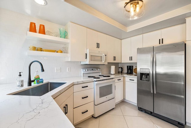 kitchen featuring backsplash, light stone countertops, sink, and white appliances