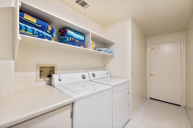 washroom featuring washing machine and dryer and light tile patterned flooring